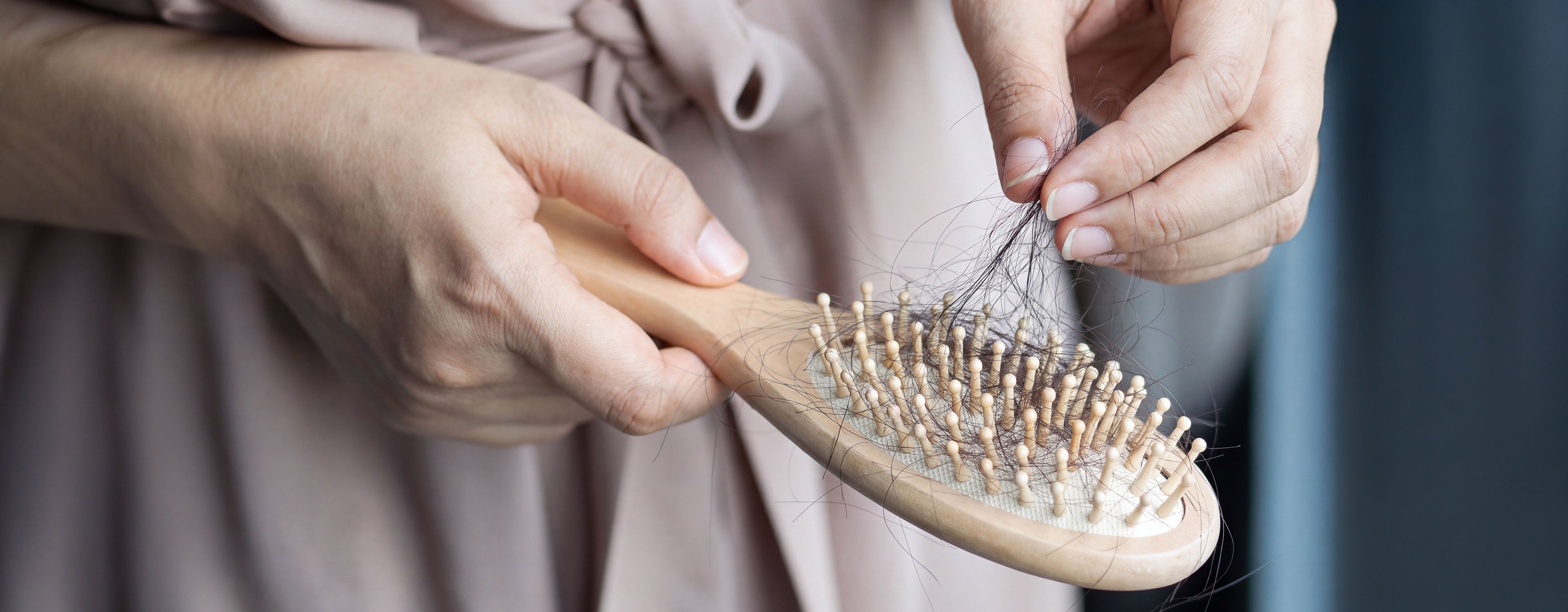 Woman removing hair from a hairbrush