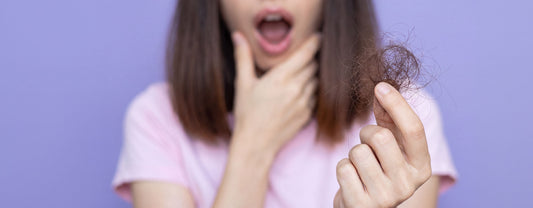 Shocked woman with hair clump in hand